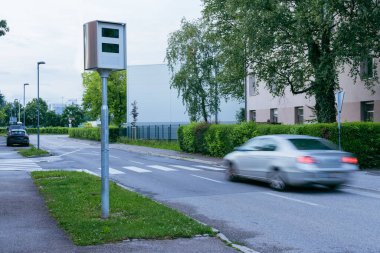 Slovenya, Ljubljana 'da akşam saatlerinde trafik radarları ya da hız tuzağı. Bulanık araçlar hız tuzağını aşıyor, yeşil çevre kentsel alanda