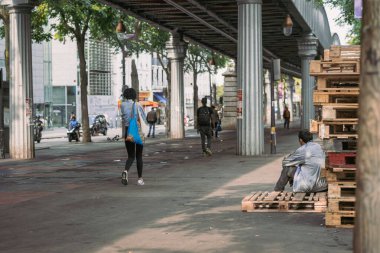 Evsizler ve göçmenler Paris 'in kuzeyindeki metro köprüsünün altında dinleniyorlar. Büyük şehirlerdeki evsizlerin sorunu, halka açık yerlerde işeme ve dilencilik.