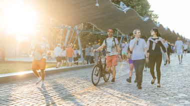 PARIS, FRANCE, 28.7.2024: İnsanlar güzel akşam saatlerinde olimpiyat evlerinin bulunduğu la villette parkında takılıyor ve yürüyor. Olimpiyat evleriyle ilgilenen kalabalık