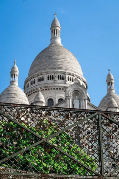 stock image Love padlocks on fence of Famous church of Sacre Coeur or Sacred Cross on top of Montmartre hill in France in morning hours. Stupid locks polluting places everywhere