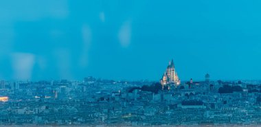Paris 'in akşam manzarası, görünür Sacre Coeur kilisesi ve yakın çevre. Yazın erken saatlerinde, kule sarı ışıklarla aydınlatılır..