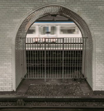 Paris 'te metro, Paris' te görülebilir yeraltı hattı, platforma doğru kemerli pencereli. Hareket halindeki tren bulanıklaşıyor.