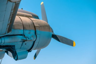 Eski piston tipi uçak motoru alttan ve arkadan görünüyor. Görünür üç pervane pervanesi ve motor etrafında kaplama.