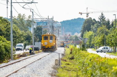 Tadilatta olan bir demiryolu çivisi üzerinde ağır makineler. Taze iz bırakıldı ve rayları düzleştirmek ve çakıl yatağını hizalamak için makineler kullanıldı.