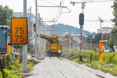 Tadilatta olan bir demiryolu çivisi üzerinde ağır makineler. Taze raylar döşendi ve rayları düzleştirmek ve çakıl yatağını hizalamak için makineler kullanıldı. Safra kaldırılıyor ve kontrol ediliyor