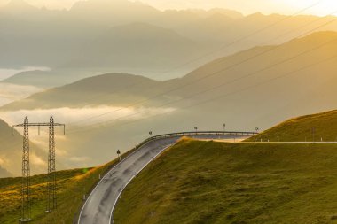 Jaufenpass ya da Passo Giovo 'dan sabahın erken saatlerinde Kuzey İtalya' daki 2100 metre yükseklikteki dağlık geçitten güzel bir panorama. Güzel gün doğumu, sisli vadi, yükselen sis, güzel bir manzara.