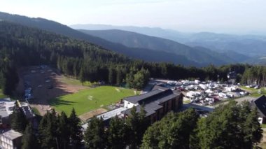 Slovenya 'nın Koroska kentindeki Kope bölgesinin görünür kayak yamacı, orman ve diğer evlerinin insansız hava aracı görüntüsü. Kuzeydoğu Slovenia 'da güneşli bir yaz gününde küçük bir kayak pisti manzarası.