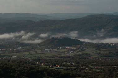 Croatian town of Buzet viewed from above. Medieval picturesque city in istria viewed from the train track up above the city. clipart