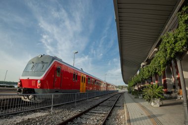Pula 'daki tren istasyonu, Hırvat kıyı kasabası. Platformun yanında yeşil yapraklı ve kırmızı mazotlu güzel tren istasyonu.