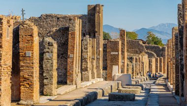Pompei 'deki birçok orijinal yoldan biri. Etrafı taş ve tuğla harabelerle çevrili. Görünür ev numaraları var. Bazıları sokağın sonunda dinlenirken görülmüş.