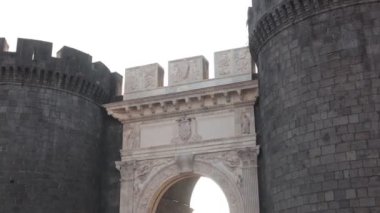 Napoli 'nin eski kasabasının Porta Capuana giriş kapısının güçlü güneş ışığıyla çekilmiş güzel bir akşam fotoğrafı. Napoli 'deki muhteşem Roma kapısı