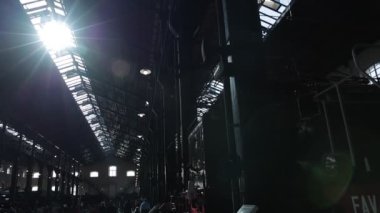 Pietrarsa Müzesi 'ndeki lokomotifler ve metal çatılar, pencerelerden içeri ışık sızıyor ve yere doğru ışık huzmeleri yapıyor. Efsanevi heybetli bina ve buhar lokomotifleri..