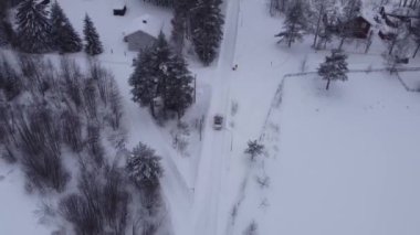 İsveç 'te asılmış köprüden geçen klasik bir arabanın destansı görüntüsü, karlı, sert bir yol, soğuk bir ortam ve eski bir araba. Nehri geçen bir arabanın insansız hava görüntüsü..