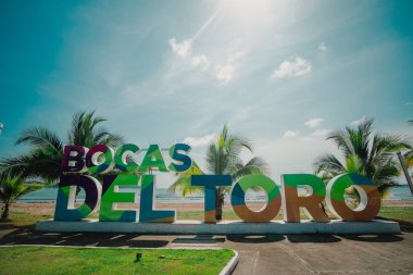 Bocas del Toro tabelası, önünde fotoğraf çekmek için sahilde büyük harfler. Turistik yerleri gösteren tipik işaretler