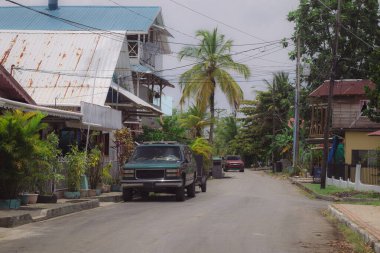 Panama 'daki Bocas del Toro turnuva merkezinin tipik caddesi. Sokakta arabaların park ettiği güneşli bir gün ve bir sürü ev..