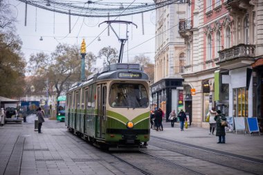 Graz şehrindeki Reininghaus 'a giden 4 numaralı klasik tramvay, merkezdeki noel süslemeli caddede sürüyor. Noel boyunca yeşil tramvayı olan renkli renkli bir cadde..