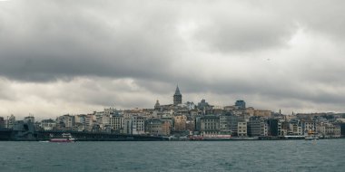İstanbul 'un karanlık ve soğuk manzarası bulanık su üzerindeki galata kulesine doğru bakıyor.