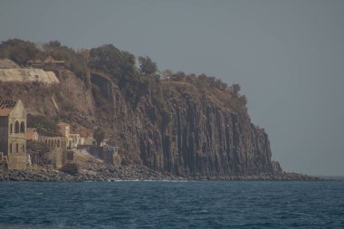 Seaside view of tall stone cliff at ilee de goree, slave island in the bay of Dakar, export point for slaves from africa to the world.. clipart