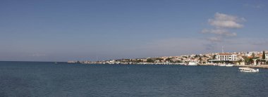 Novalja Körfezi Panoraması. Görülebilir mavi kristal su ve evler suya doğru dizilmiş. Etrafta yüzen tekneler, yaz havası...