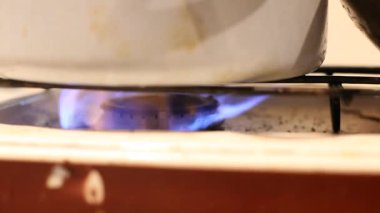 Propan gazı ya da gaz ocağı olan eski kirli mutfak sobası. İçinde soğan olan tavalar kızarıyor..