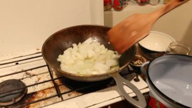 Propan gazı ya da gaz ocağı olan eski kirli mutfak sobası. İçinde soğan olan tavalar kızarıyor..