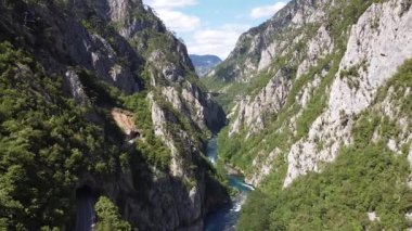 Narrow gorge of Piva river canyon close to the high road bridge over the valley. Green vertical rock formations and blue sky in the background, close to durmitor and Mratinje hydroelectric dam