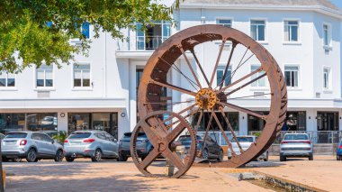 Ana şehir meydanındaki Stellenbosch, Güney Afrika 'da bulunan bir ekran üzerindeki tahıl değirmenine güç veren paslı çelik çarklar. Güneşli bir gün..
