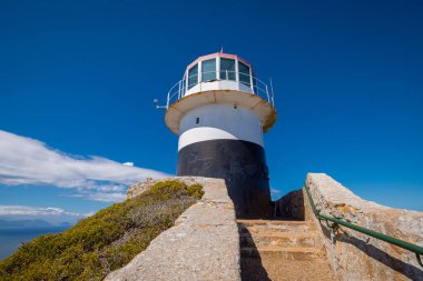 Cape Point 'teki destansı bir deniz fenerinin ön görüntüsü ya da umudun pelerini. Sıcak bir yaz gününde kurbağa manzarası, insan yok, mavi gökyüzü. Afrika 'da deniz feneri, Strair manzarası..