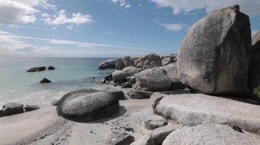 Güney Afrika 'daki Simons Körfezi' ne yakın penguenlerle dolu büyüleyici kayalar. Dev taş kayaların yanındaki penguen kolonisi ya da sığınağı. Güneşli sıcak bir gün.
