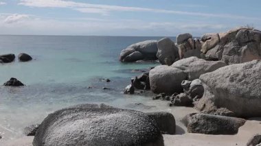 Güney Afrika 'daki Simons Körfezi' ne yakın penguenlerle dolu büyüleyici kayalar. Dev taş kayaların yanındaki penguen kolonisi ya da sığınağı. Güneşli sıcak bir gün.