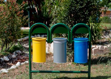 three metal containers for different garbage- paper, organic, plastic, glass. Separation and sorting of rubbish