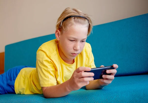 happy teenager looking at cell phone in living room at home