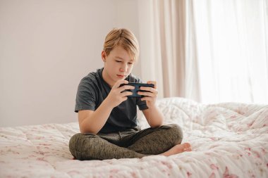 caucasina boy holding a phone