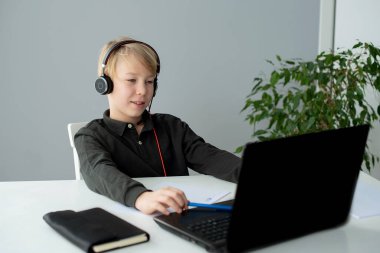 teenage boy studying at home with laptop