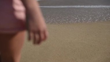 Sahilde altın kum üzerinde ayak izleri kapalı wahing deniz dalgalarının 4k closeup görüntüleri