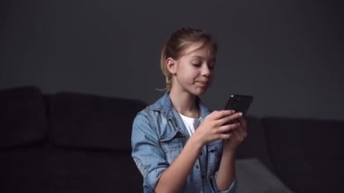 4k  girl hold smartphone, watching social media in modern living room.