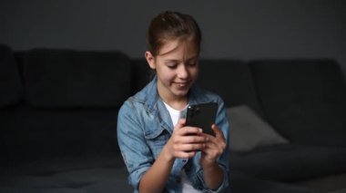 4k  girl hold smartphone, watching social media in modern living room.