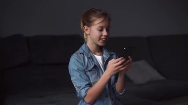 4k  girl hold smartphone, watching social media in modern living room.