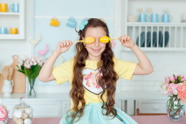 Portrait of cute girl and yellow Easter eggs , closes eyes with testicles
