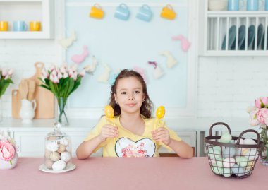 Happy Easter. A cute girl holds colored eggs in her hands and smiles cheerfully.
