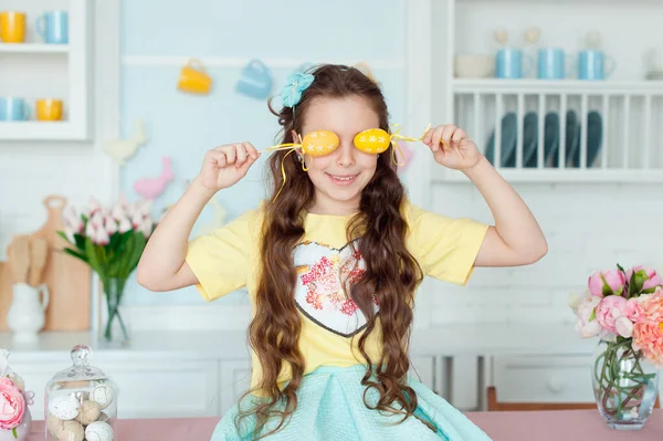 Portrait of cute girl and yellow Easter eggs , closes eyes with testicles