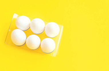 Sarı arka planda beyaz yumurtalar