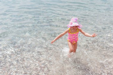 Kumsal tatilinde gülümseyen sevimli küçük kız.