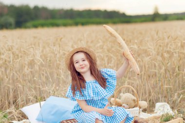Little beautiful smiling girl on a gold wheat field. Girls in the grain-field.