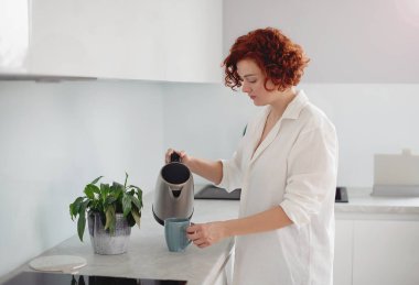 Young beautiful woman making morning coffee , preparing a cup of latte for breakfast