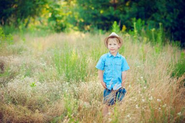 Little boy enjoying life and nature. Happy Kid on summer field . Fresh air, environment concept.