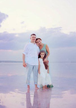 Kumsalda mutlu bir aile. İnsanlar yaz tatilinde eğleniyor. Baba, anne ve çocuk denizlere ve gökyüzüne karşı. Tatil seyahati kavramı