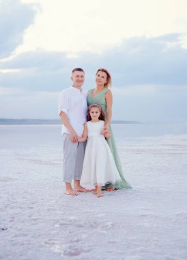 Kumsalda mutlu bir aile. İnsanlar yaz tatilinde eğleniyor. Baba, anne ve çocuk denizlere ve gökyüzüne karşı. Tatil seyahati kavramı