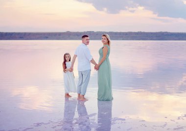 Kumsalda mutlu bir aile. İnsanlar yaz tatilinde eğleniyor. Baba, anne ve çocuk denizlere ve gökyüzüne karşı. Tatil seyahati kavramı