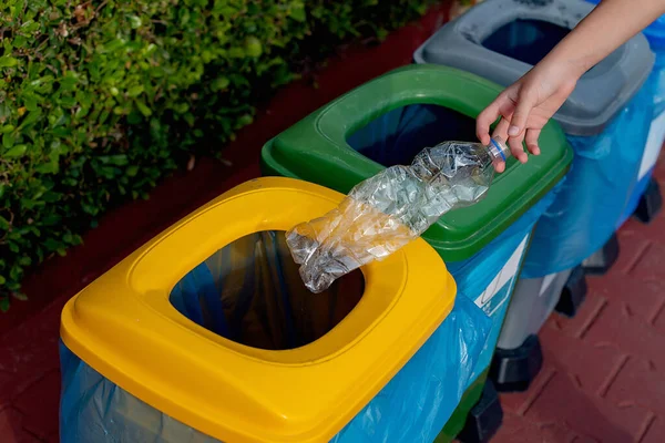 stock image Close up hand throwing plastic bottle recycling container garbage sorting rubbish collection bin. Hand put bottle plastic trash can. Reduce waste recycle bins. Garbage recycling plastic trash bins